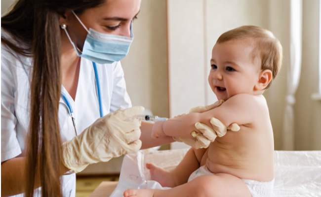 female pediatrician nurse giving vaccine hand little baby